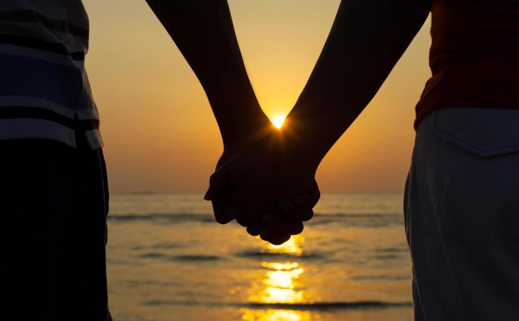 couple-holding-hands-at-sunset-free-photo
