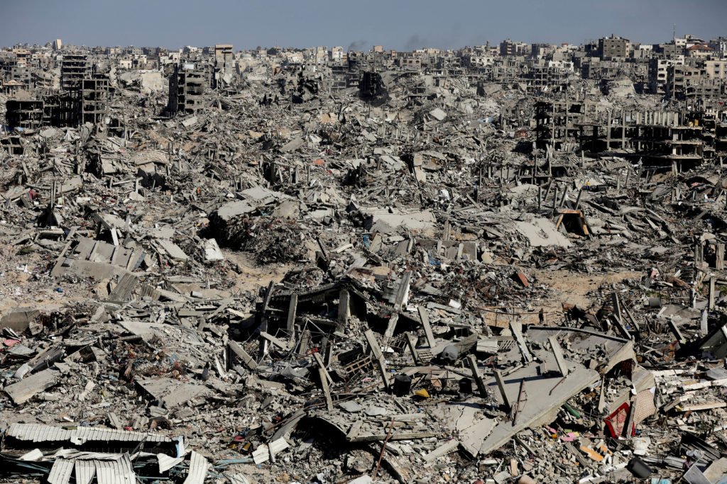 Palestinians make their way past the rubble of destroyed houses and buildings in Jabalia